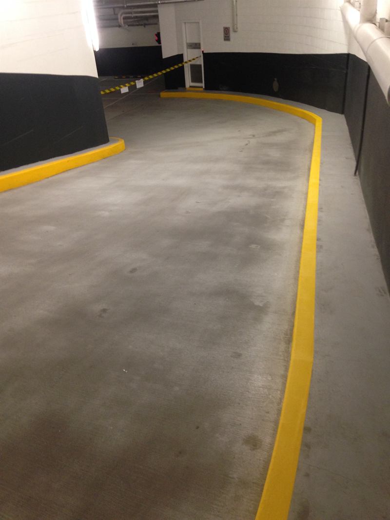Yellow painted kerb lining a carpark ramp
