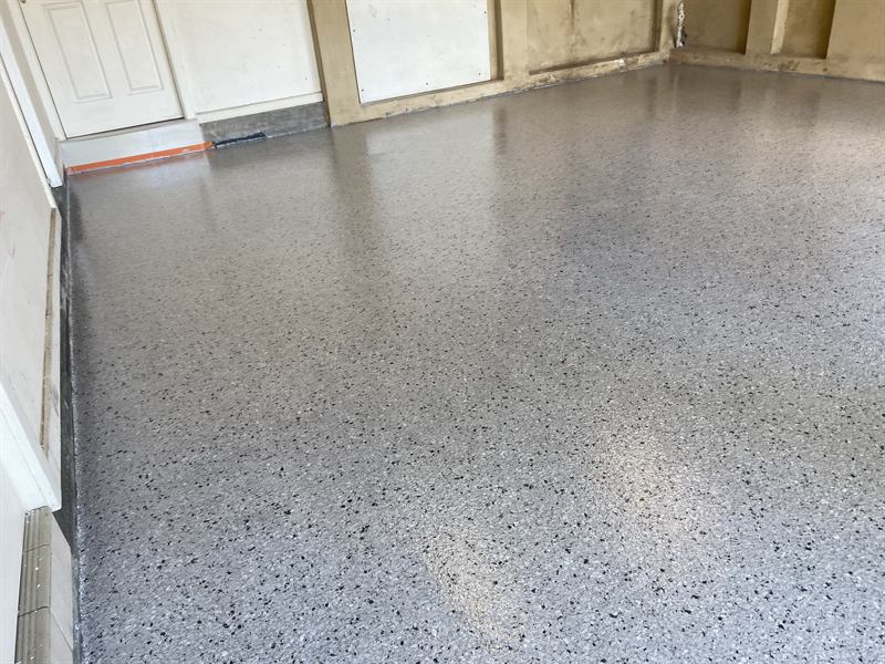 Residential garage floor finished in grey epoxy with decorative flake