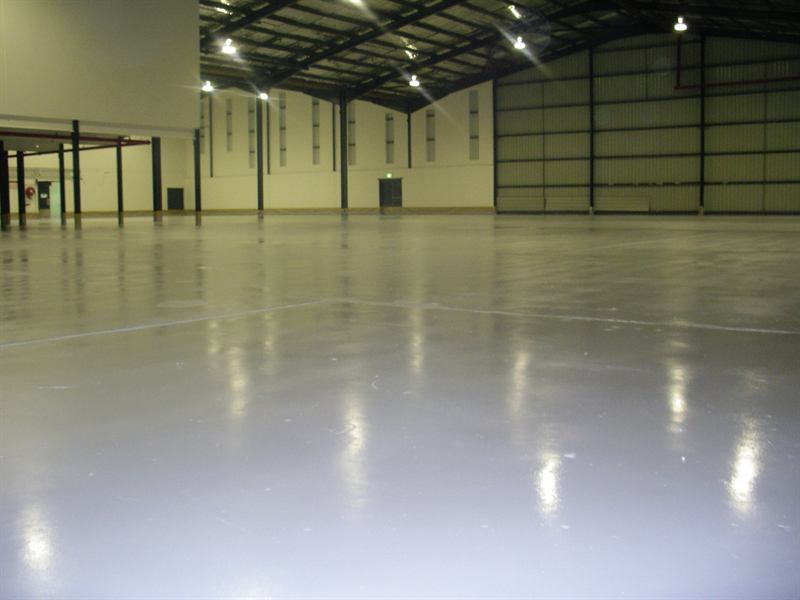 Large warehouse floor finished in glossy light grey epoxy