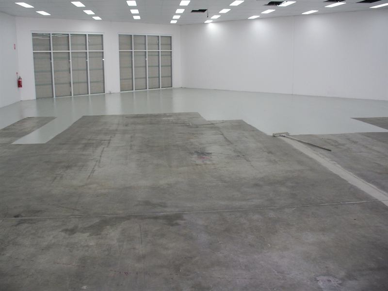 Showroom floor before: bare concrete, partly coated