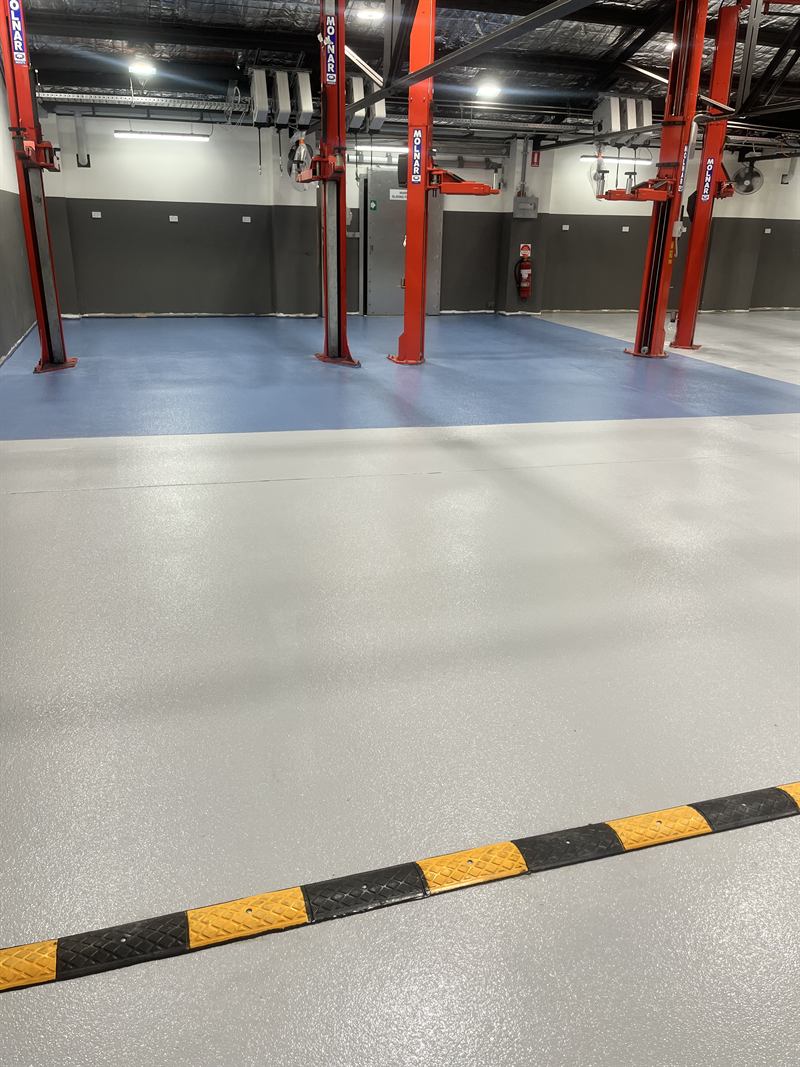 Workshop floor after: light grey finish with yellow and black safety lines