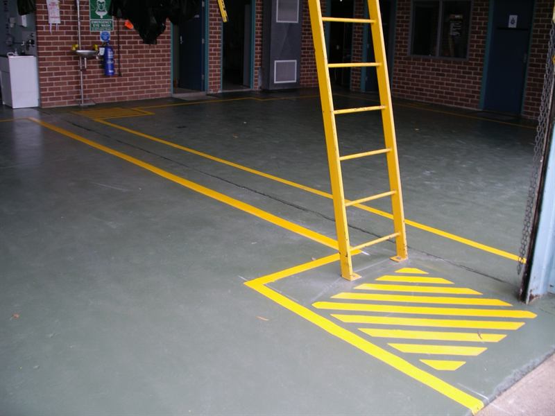 Yellow safety hatching and walkway lines at a building entry