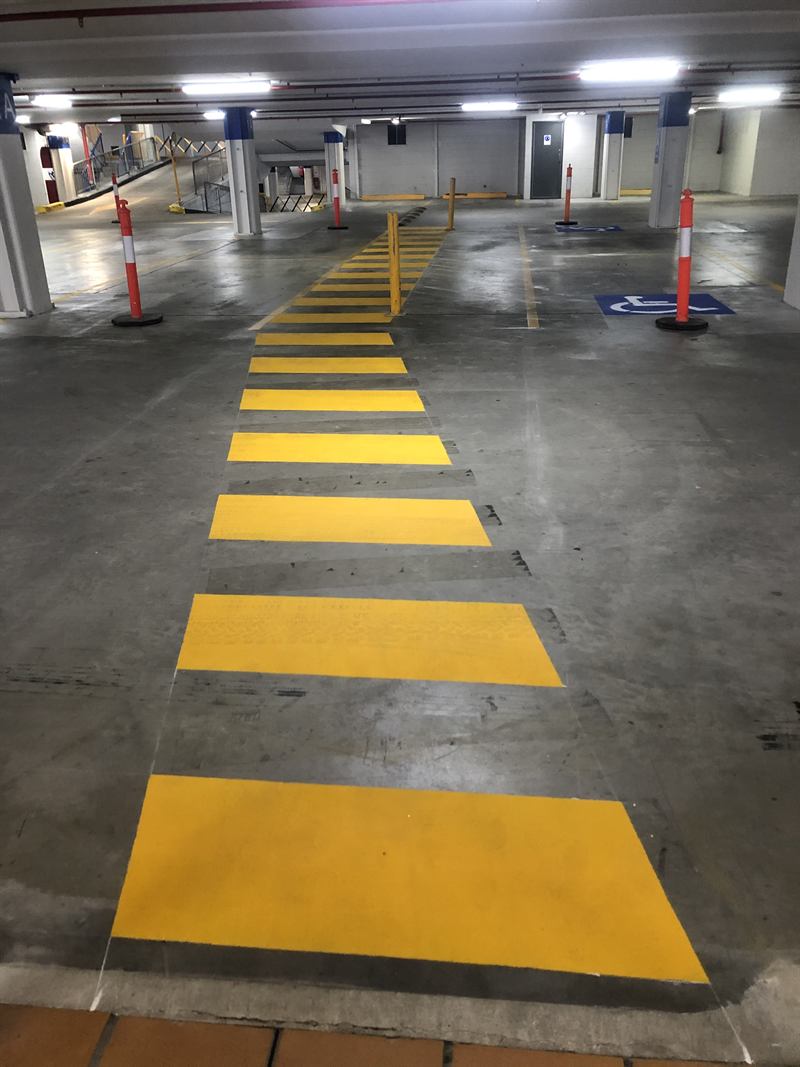 Yellow pedestrian crossing linemarked through a basement carpark