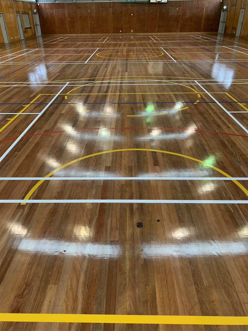 Sports court lines on a timber school hall floor